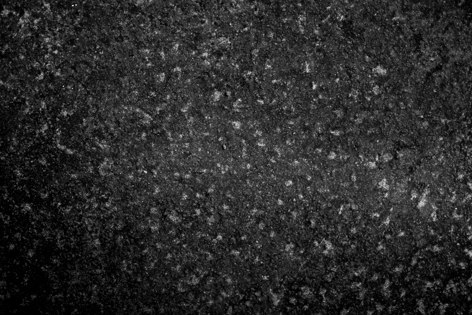 Dark speckled aggregate surface with small light flecks